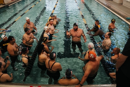 Team Army athletes receive event instructions from coach Ross Alewine, center, during the swimming event at the 2024 Army Trials, Fort Liberty, North Carolina