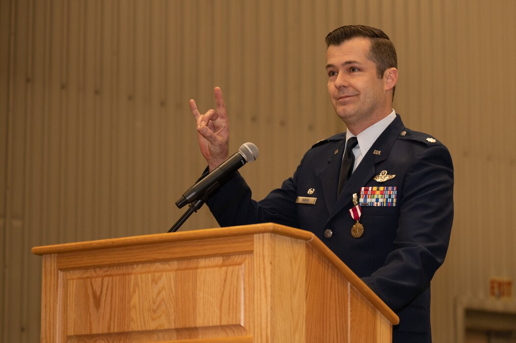 A squadron commander renders a signature hand gesture that symbolizes the squadron's mascot.