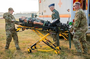 Airmen transport an injured person on a stretcher