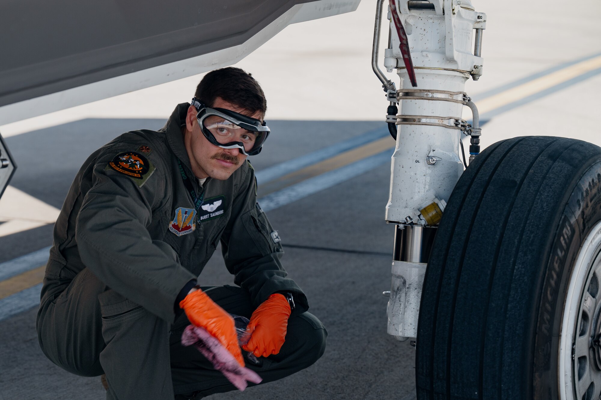 U.S. Air Force Maj. Zach Saunders, F-35 division commander assigned to the 422nd Test and Evaluation Squadron, performs post-flight checks on the tires of an F-35 Lightning II as part of independent pilot off-station procedures (IPOP) at Nellis Air Force Base, Nevada, April 1, 2024.