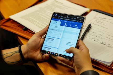 A person holds an electronic tablet displaying job postings.