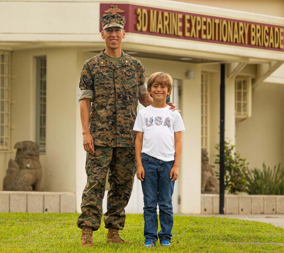 Maj. Marcos Azua, the comptroller for the 3rd Marine Expeditionary Brigade, poses with his son, Martin, on Camp Courtney, Okinawa, Japan, April 12, 2024. The Month of the Military Child, celebrated annually in April, recognizes military children for the daily sacrifices and challenges they overcome. (U.S. Marine Corps photo by 1st Lt. Samuel H. Barge)