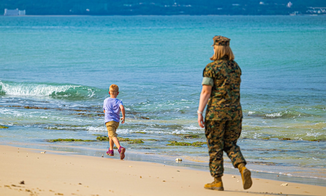 Lt. Col. Melissa Blyleven, a logistics planner with the III Marine Expeditionary Force, follows her son, Sam, at Camp Courtney Beach, Okinawa, Japan, April 15, 2024. The Month of the Military Child, celebrated annually in April, recognizes military children for the daily sacrifices and challenges they overcome. (U.S. Marine Corps photo by 1st Lt. Samuel H. Barge)
