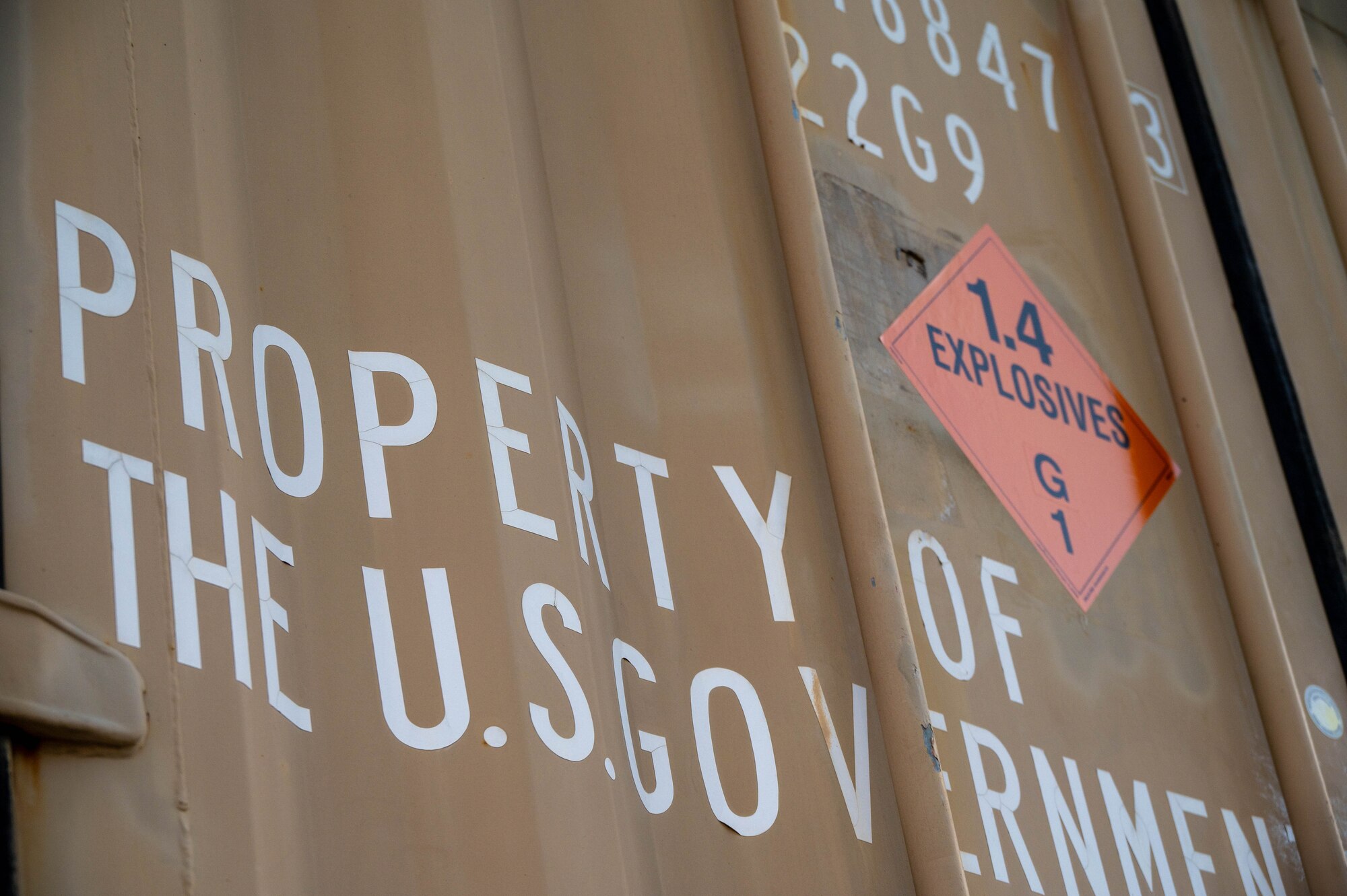 A shipping container reads “PROPERTY OF THE U.S. GOVERNMENT”