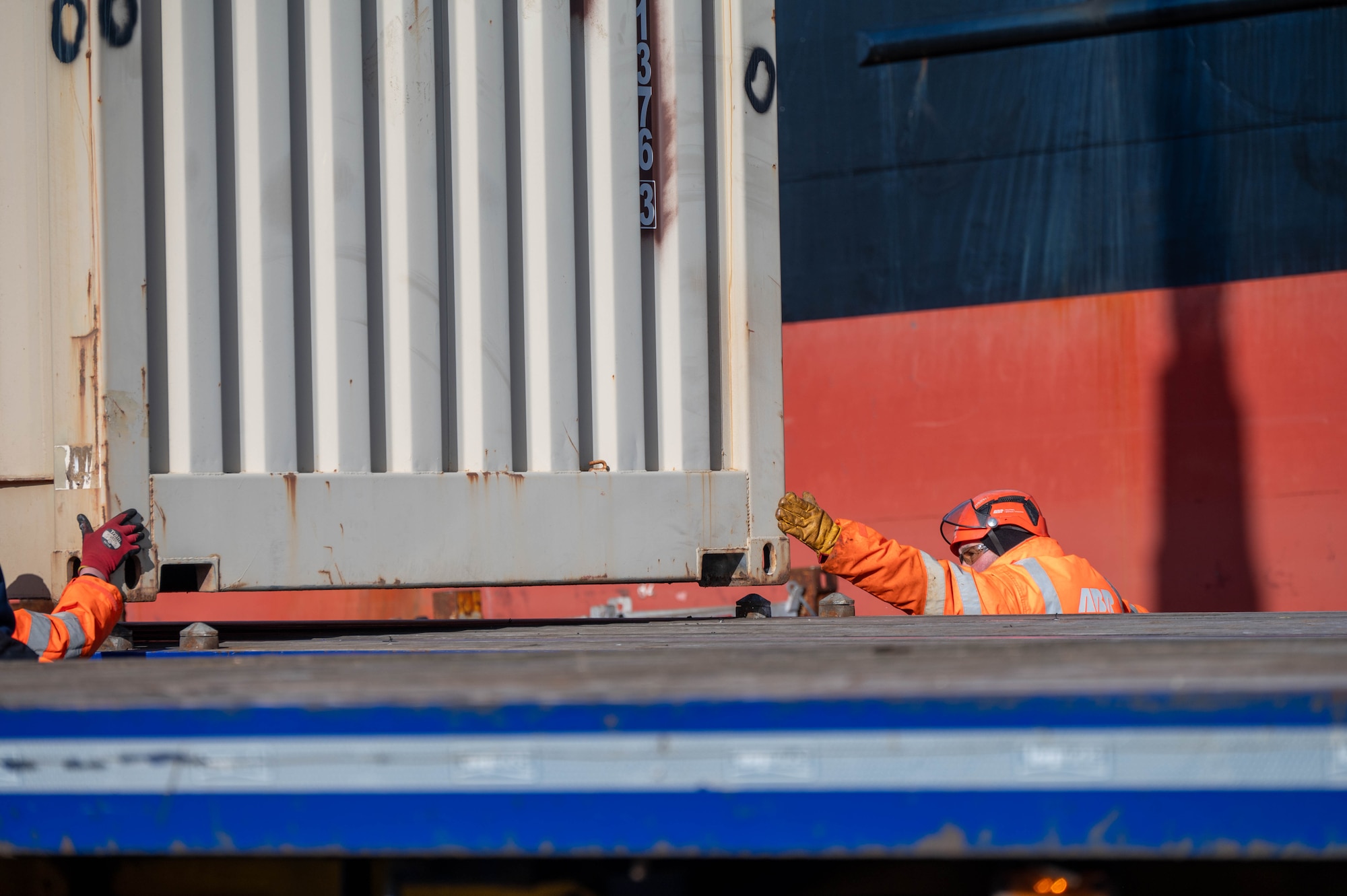 Personnel guide a shipping container off of the MV Sagamore cargo ship