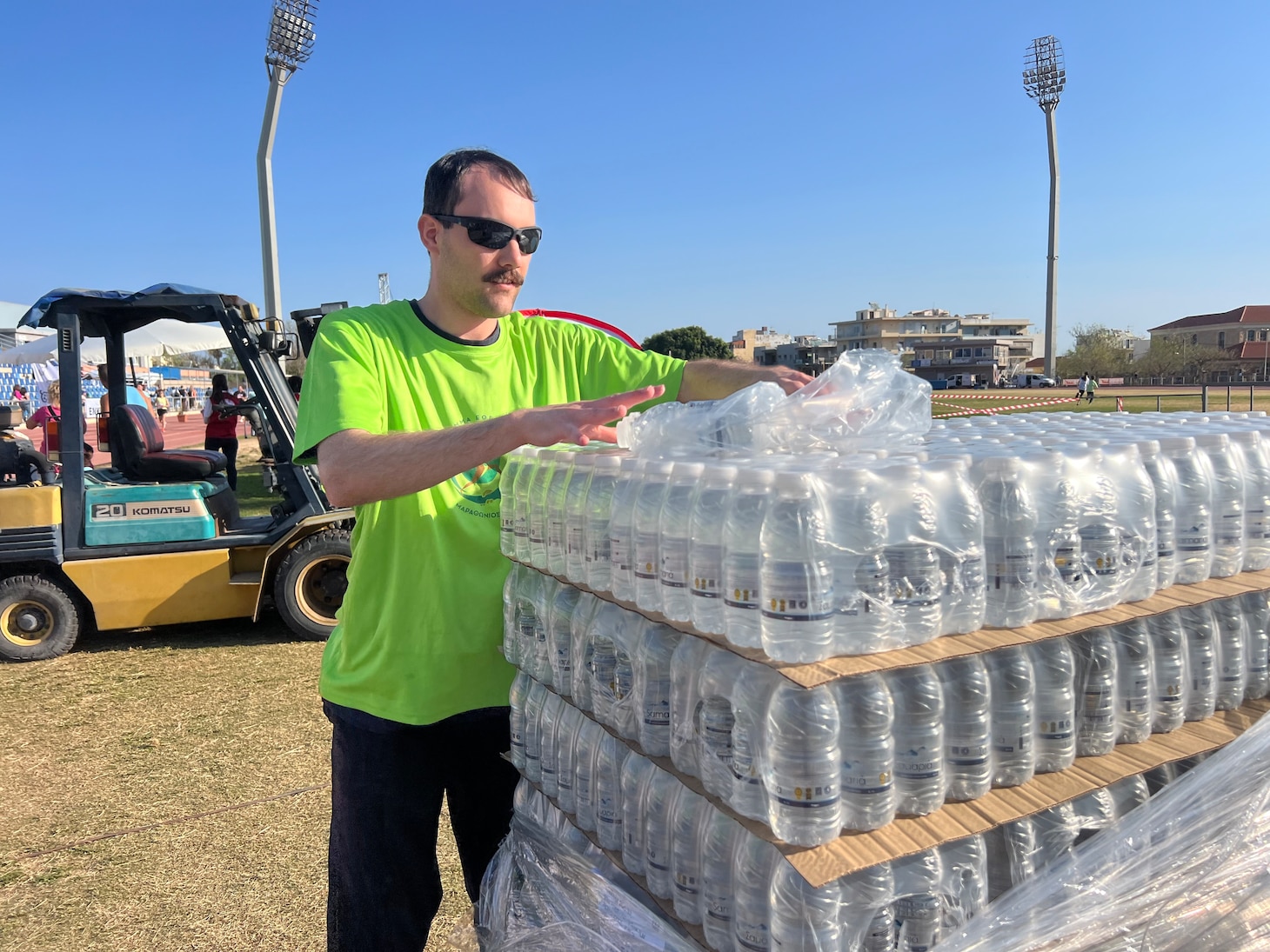 Builder 3rd Class Anthony Sacco, assigned Naval Facilities Engineering Systems Command, Europe, Africa, Central, distributes bottled water to participants in the Crete Marathon in Chania, Crete, Greece on April 14, 2024.