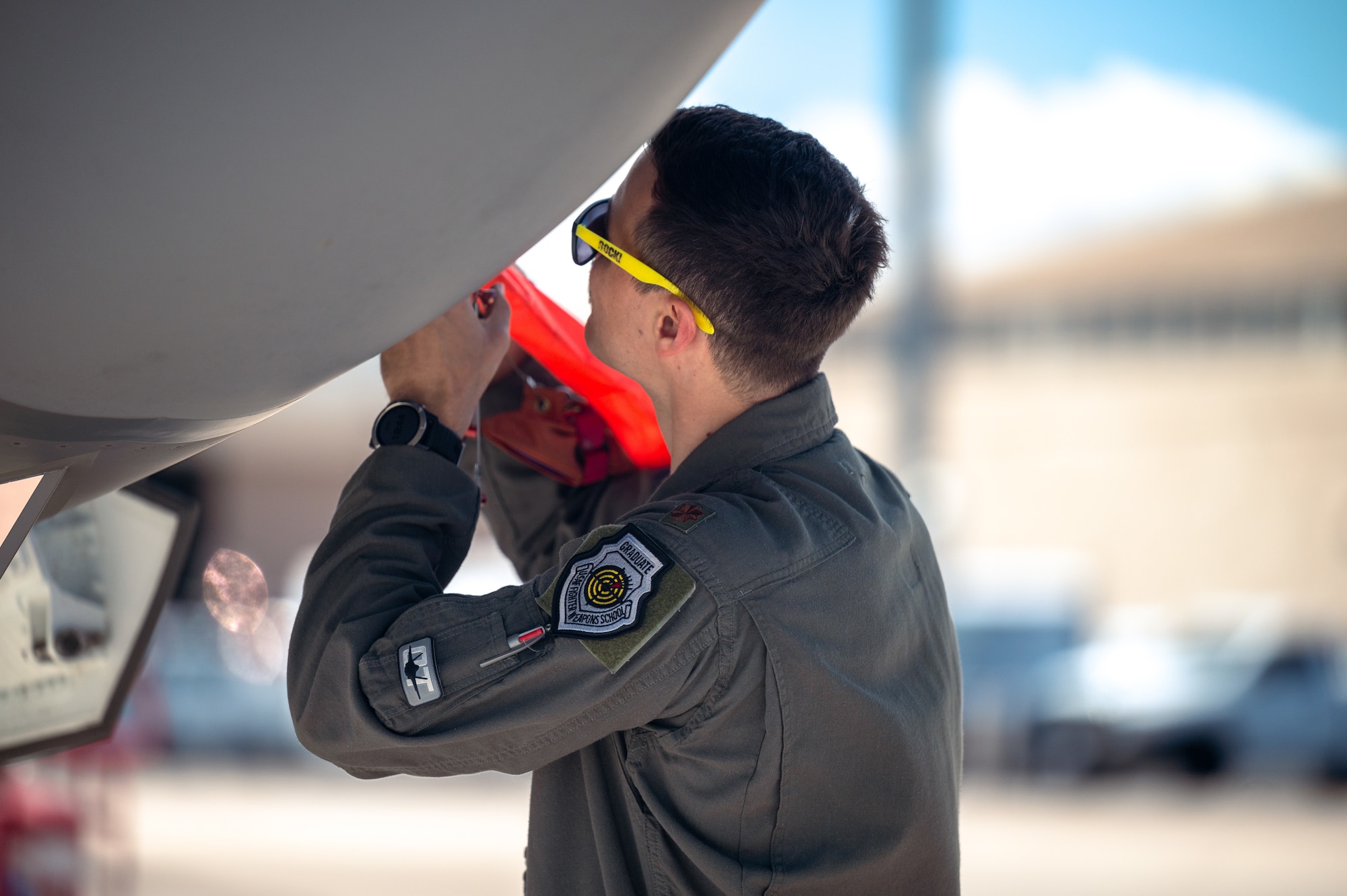 U.S. Air Force Maj. Zach Saunders, an F-35 division commander assigned to the 422nd Test and Evaluation Squadron, secures a warning tag on an F-35 Lightning II as part of independent pilot off-station procedures (IPOP) at Nellis Air Force Base, Nevada, April 1, 2024.