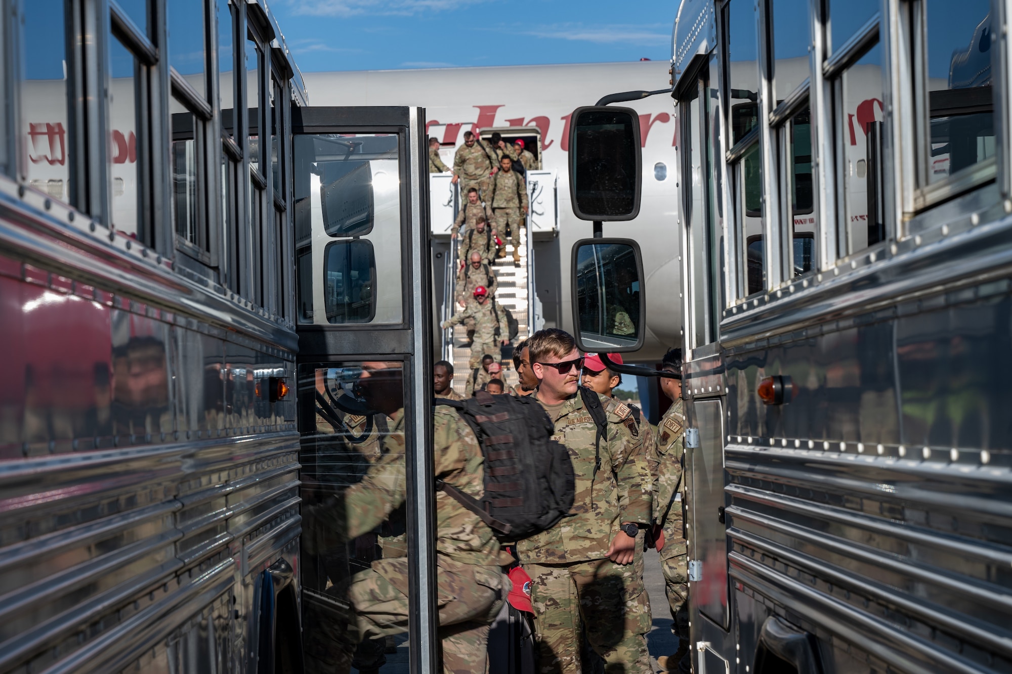 U.S. Air Force Airmen, assigned to the 823d Rapid Engineer Deployable Heavy Operational Repair Squadron Engineer, load onto a bus to reunite with their families at Hurlburt Field, Florida, April 14, 2024. Airmen from the 823d RED HORSE spent six and a half months in Guam to restore and activate old runways in order to deter adversaries. (U.S. Air Force photo by Senior Airman Hussein Enaya)