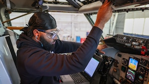 Man working aircraft controls with laptop