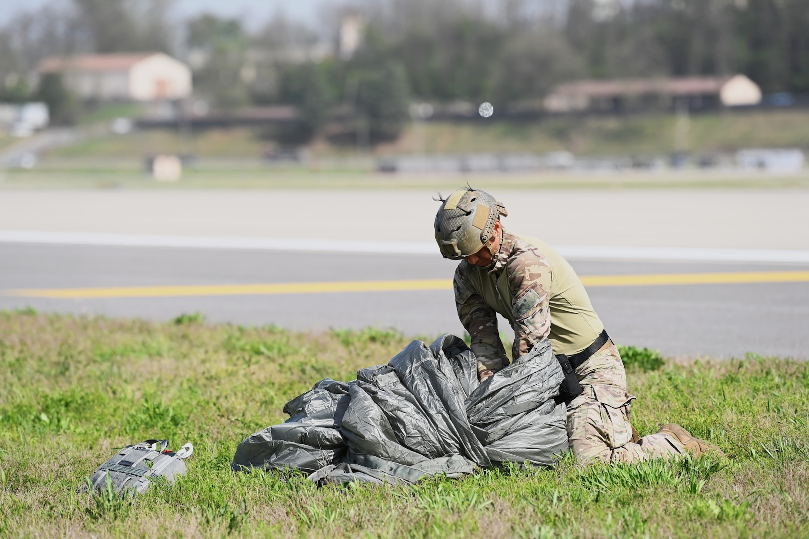 A member assigned to U.S. Special Operations Command Korea gathers his parachute on the flightline at Osan Air Base, Republic of Korea, April 18, 2024. Approximately 300 U.S. and Republic of Korea special operations forces personnel participated in a static-line Airborne training operation as part of Korea Flying Training 24, a combined ROK and U.S. exercise running April 12-26. (U.S. Air Force photo by Tech. Sgt. Ericka McCammon)