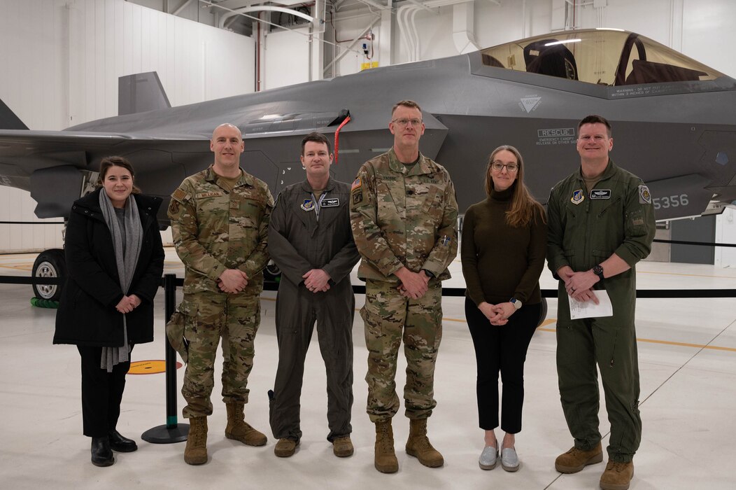 A group of military and Department of Defense personnel stand for a photo.