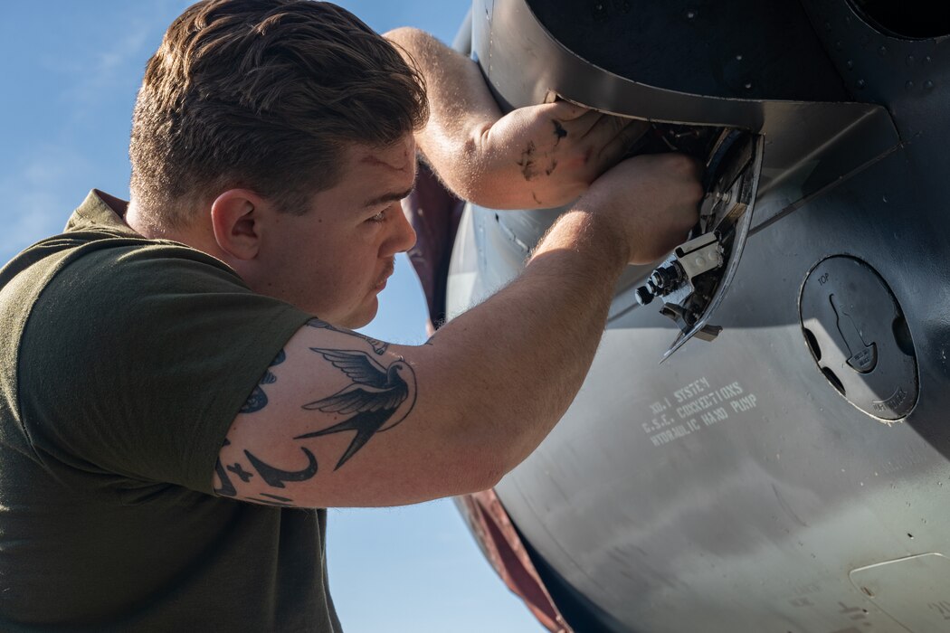 A plane captain performs maintenance on an aircraft.