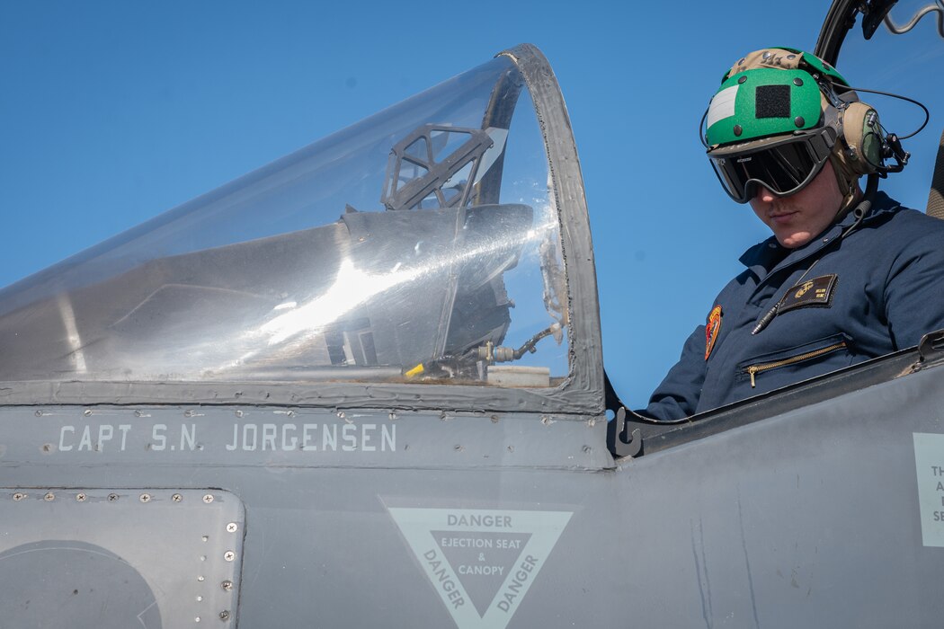 A plane captain performs a cockpit inspection.