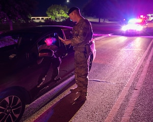 U.S. Air Force Staff Sgt. Siree Contreras, left, 47th Security Forces Squadron (SFS) noncommissioned officer in charge of police services, is given a ticket for distracted driving in a photoshoot with Staff Sgt. Ronnie Moore, right, 47th SFS flight sergeant, for Distracted Driving Awareness Month at Laughlin Air Force Base, Texas, April 4, 2024.  Distracted Driving on Laughlin has an escalating punishment, starting with a 15 day suspension of driving and leading up to a 6 month suspension. (U.S. Air Force photo by Staff Sgt. Nicholas Larsen)