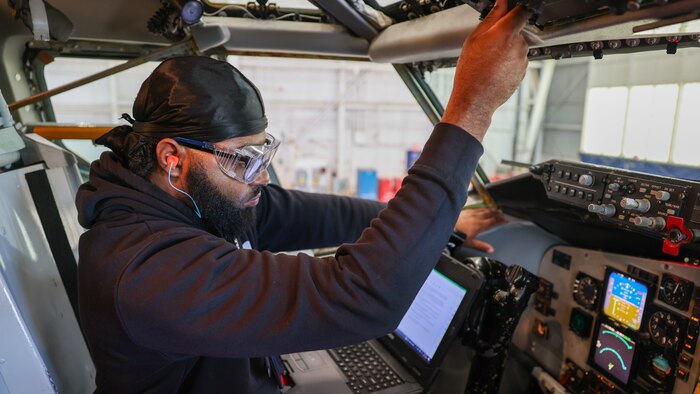 Man working aircraft controls with laptop