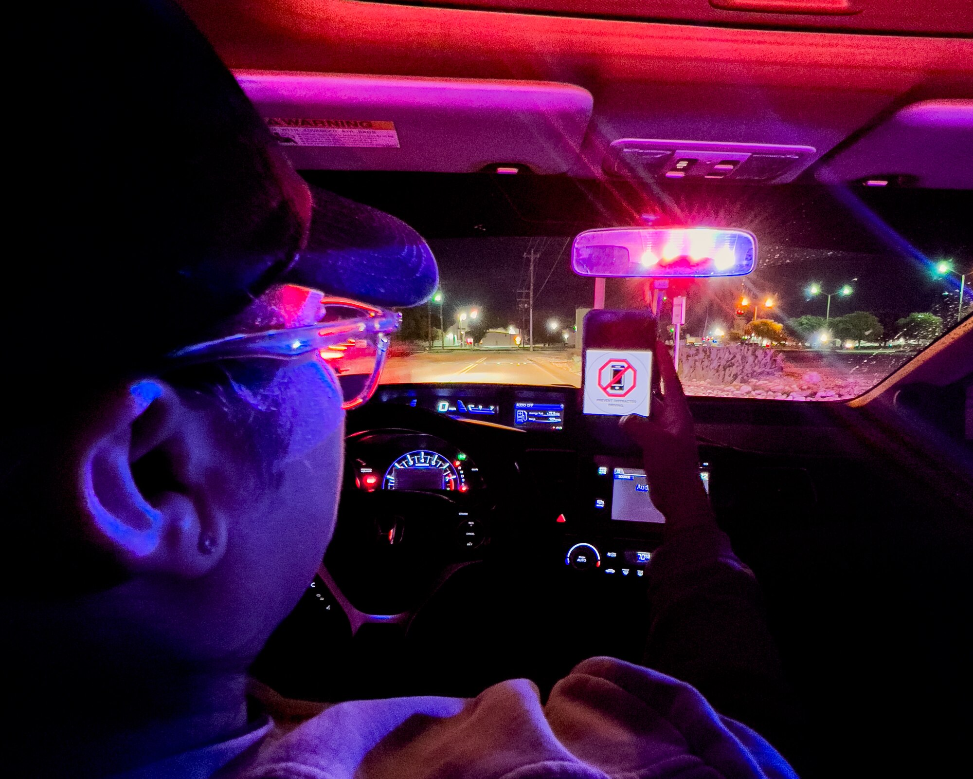 U.S. Air Force Staff Sgt. Siree Contreras, 47th Security Forces Squadron (SFS) noncommissioned officer in charge of police services, holds up her phone displaying a Prevent Distracted Driving photo at Laughlin Air Force Base, Texas, April 4, 2024. April is Distracted Driving Awareness Month and the 47th SFS is looking to spread awareness of the causes and consequences of distracted driving. (U.S. Air Force photo by Staff Sgt. Nicholas Larsen)