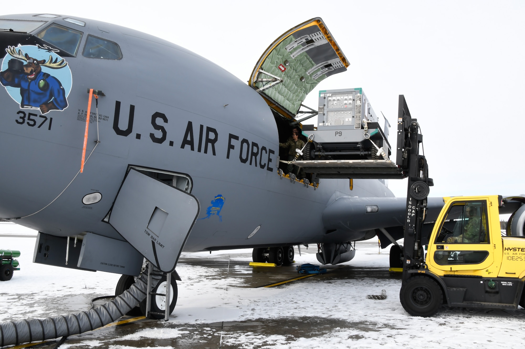 U.S. Air National Guard Master Sgt. Anthony Accardi, 168th Logistics Readiness Squadron, loads equipment on an Alaska Air National Guard KC-135 Stratotanker with the help of Tech. Sgt. Melina Arciniega, a boom operator, 168th Operations Group, while preparing to deploy from Eielson Air Force Base to Exercise Agile Reaper 24-1 at Andersen AFB, Guam.