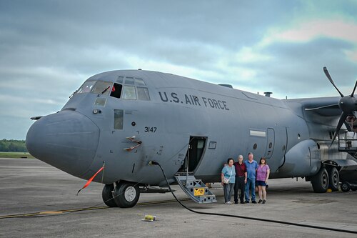 A family stands in front of an aircraft