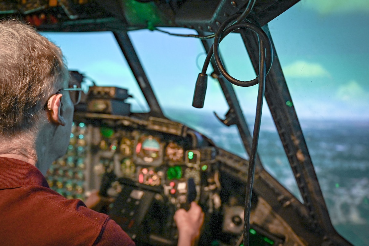 A person sits in a flight simulator