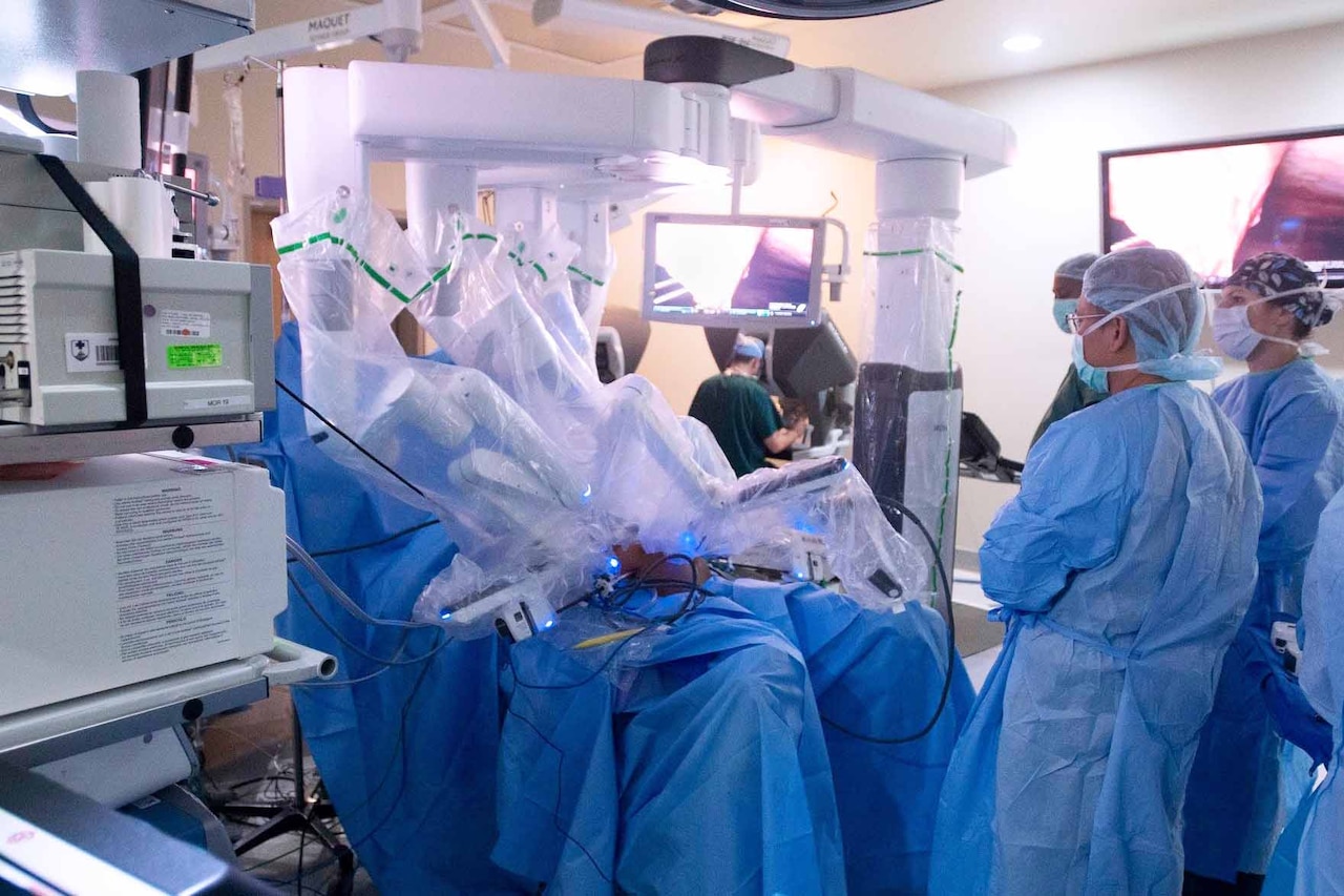 Doctors use a robot to perform surgery on a patient.