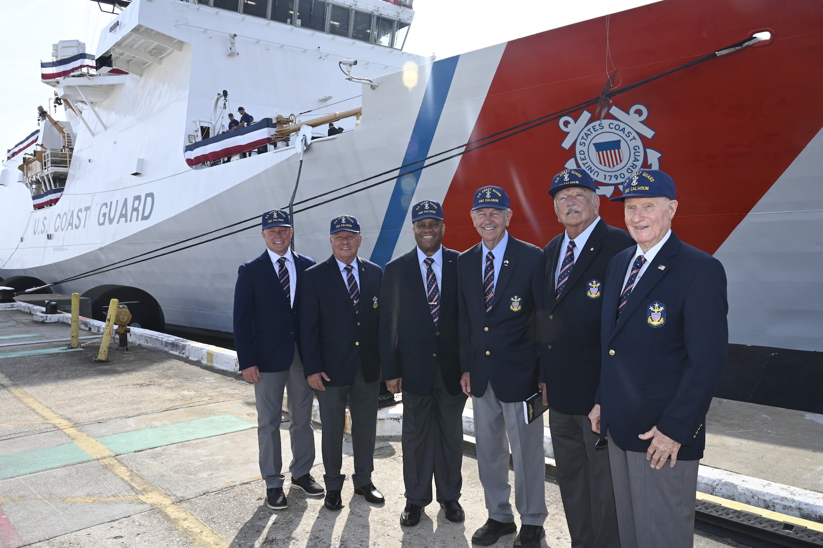 Former Master Chief Petty Officers of the Coast Guard stand in front of the Coast Guard Cutter Calhoun (WMSL 759), which is named for the first Master Chief Petty Officer of the Coast Guard (MCPOCG), Charles Calhoun, April 20, 2024, in North Charleston, South Carolina. From left, MCPOCG #13 Jason Vanderhaden, MCPOCG #10 Skip Bowen, MCPOCG #8 Vince Patton, MCPOCG #7 Eric Trent, MCPOCG #6 Jay Lloyd, and MCPOCG #3 Hollis Stephens. (U.S. Coast Guard photo by Senior Chief Petty Officer Nick Ameen)