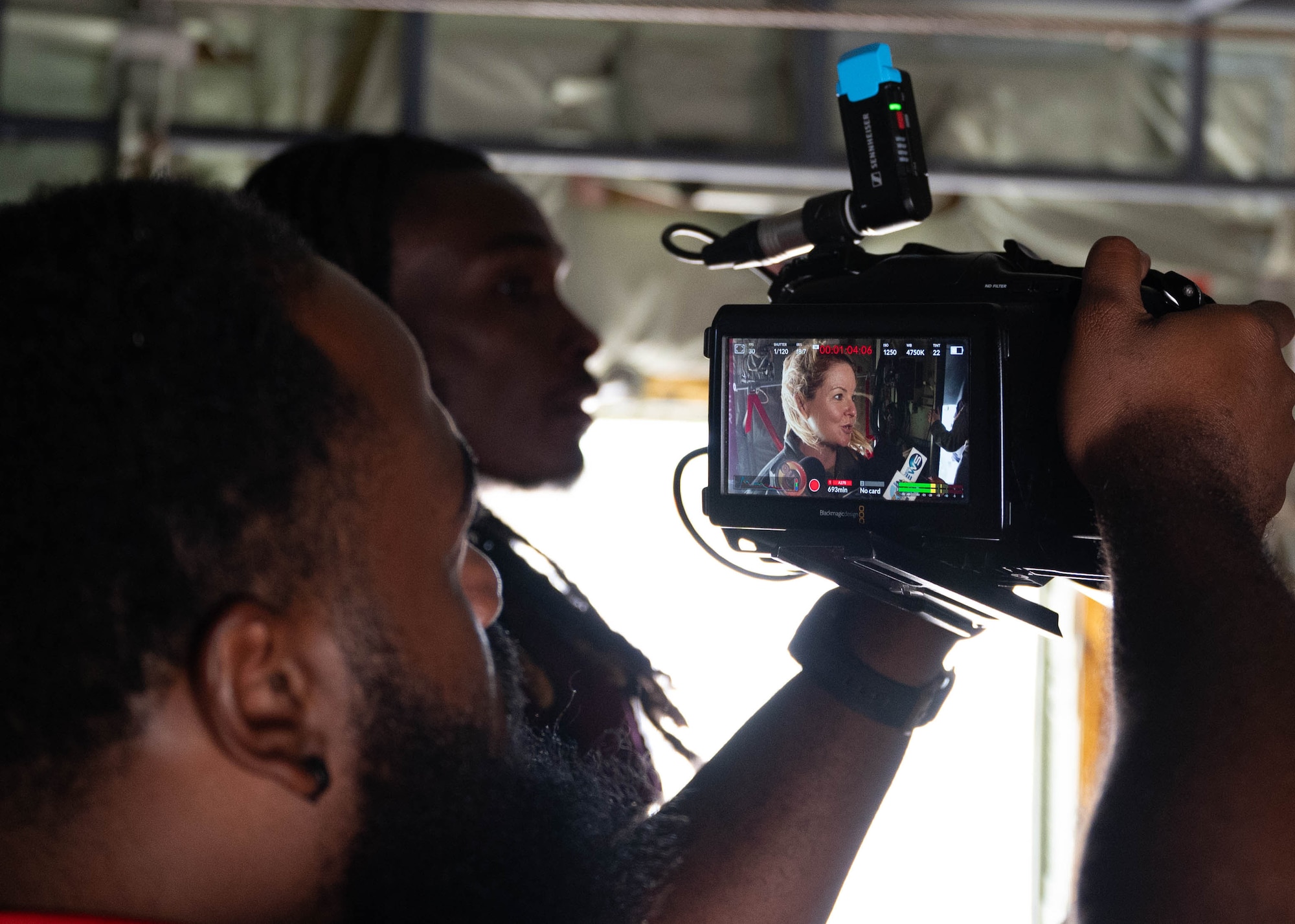 Guy holding camera, taking photo of an Airman