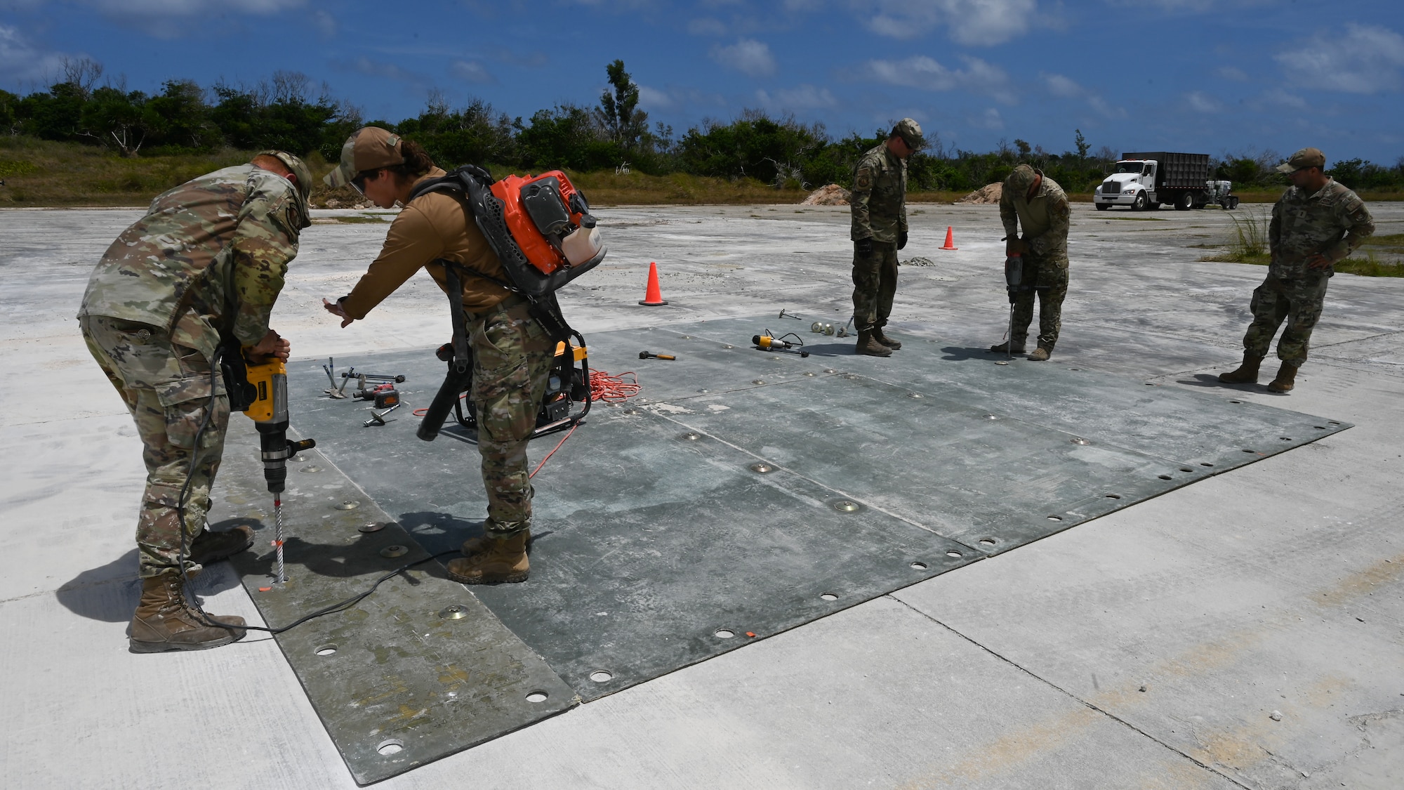 Airmen drills in a large polymer matting over the filled crater.