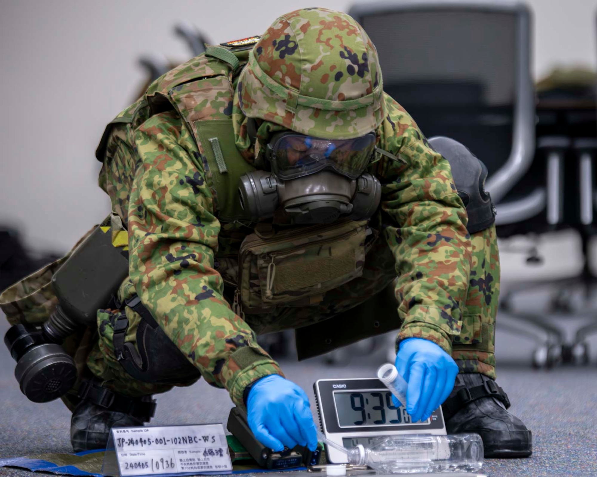 A Japanese military member collects a sample.