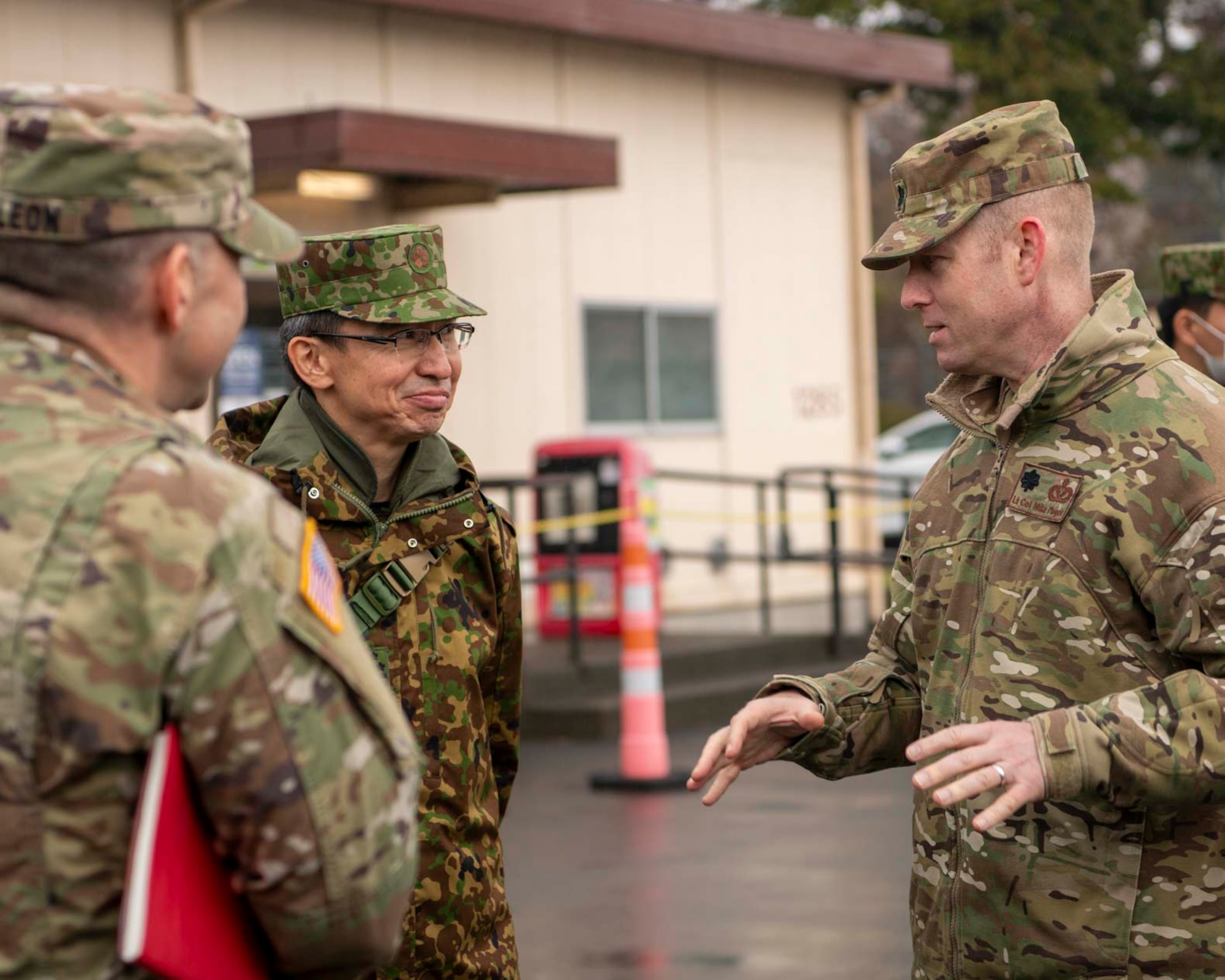 A Japanese military member speaks to U.S. military members.