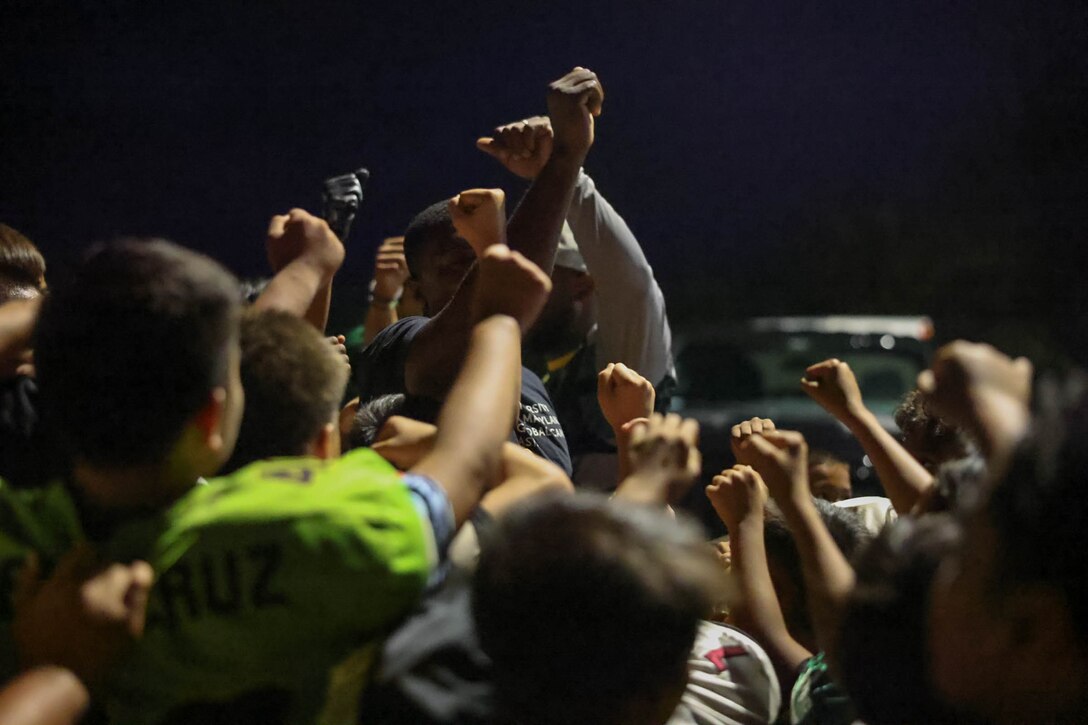 U.S. Marine Corps Sgt. Jacari Williams, a native of New Orleans and a personnel chief stationed on Marine Corps Base Camp Blaz, gathers the team together to do a motivational “hands in the middle” group huddle, April 10, 2024. Williams in his free time helps coach the Guam Green Bay Packers, a youth football group, to inspire them to find success in life with what he teaches through football. “The kids push through,” said Williams. “They already deal with adversity in their everyday lives so football is an outlet for them to express themselves and find some success in doing the right thing while making their family proud at the same time.” (U.S. Marine Corps photo by Lance Cpl. Rey Moreno Marilao)