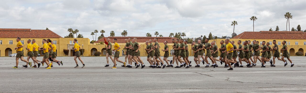 A wide shot of Marine Corps recruits running.