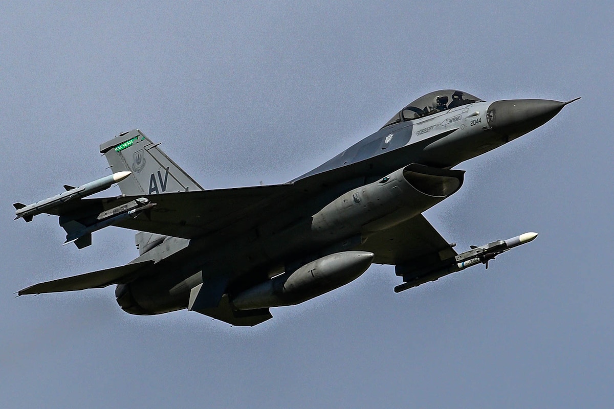 An F-16 flies through the sky.