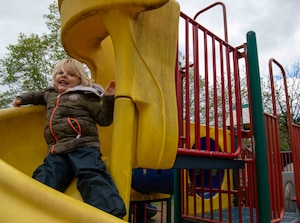 A German child goes down a slide at Donnelly Park, Ramstein Air Base, Germany, April 18, 2024. The Villa Winzig Tour gives German children the opportunity to visit the base and introduce English to German children with the intent to deepen the U.S. and German Bond. (U.S. Air Force photo by Airman Dylan Myers)