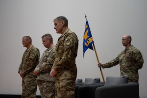 U.S. Air Force Brig. Gen. Douglas Jackson, 379th Air Expeditionary Wing commander, left, and the 379th Expeditionary Air Base Group command team hold a moment of silence with Col. Jeff Mrazik, 379th EABG commander, during the 379th EABG change of command ceremony at an undisclosed location within the U.S. Central Command area of responsibility, April 19, 2024.