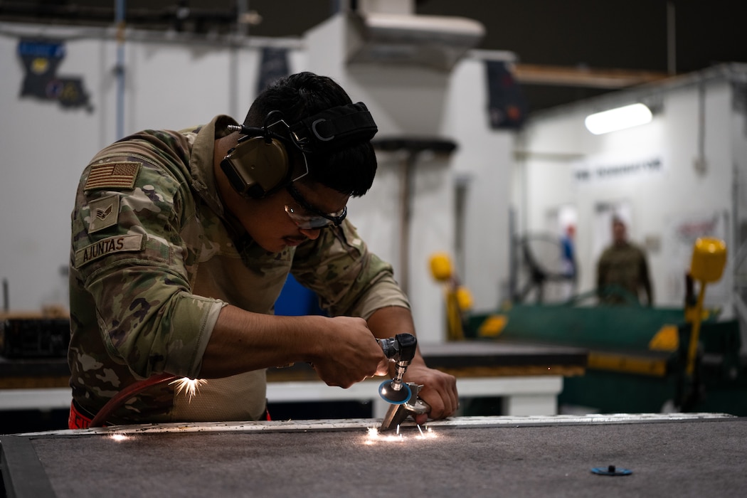A U.S. Air Force aircraft metals techonology journeyman grinds a piece of titanium at an undisclosed location within the U.S. Central Command area of responsibility, April 16, 2024.