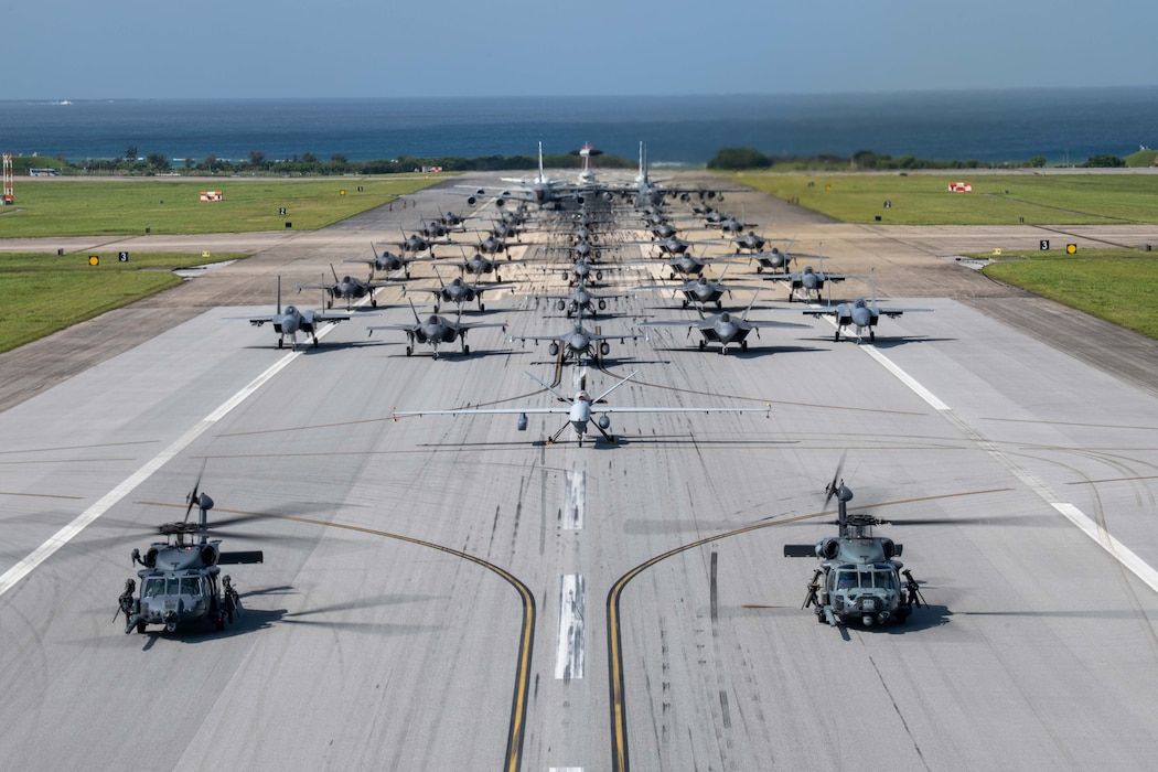 U.S. Air Force and Navy aircraft, including an HH-60W Jolly Green II, HH-60G Pave Hawk, MQ-9 Reaper, F-16 Fighting Falcons, F-22 Raptors, F-35A Lightning IIs, F-15C Eagles, a RC-135 Rivet Joint, KC-135 Stratotankers, a Navy P8 Poseidon and an MC-130J Commando II, line up on the runway