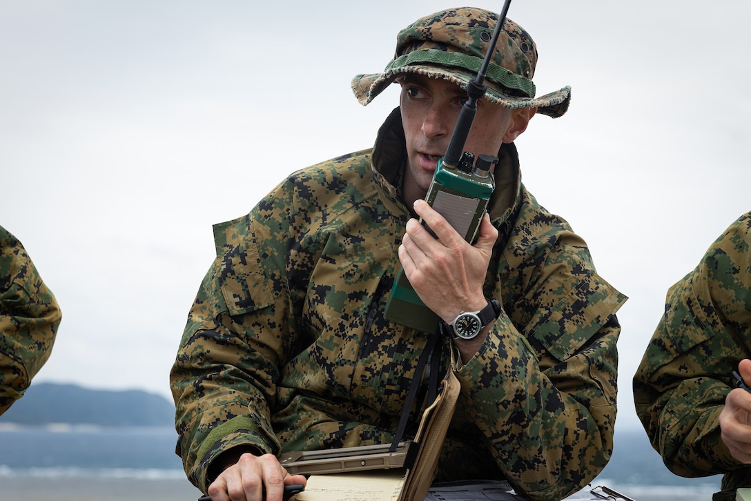 A Marine speaks into a walkie-talkie.
