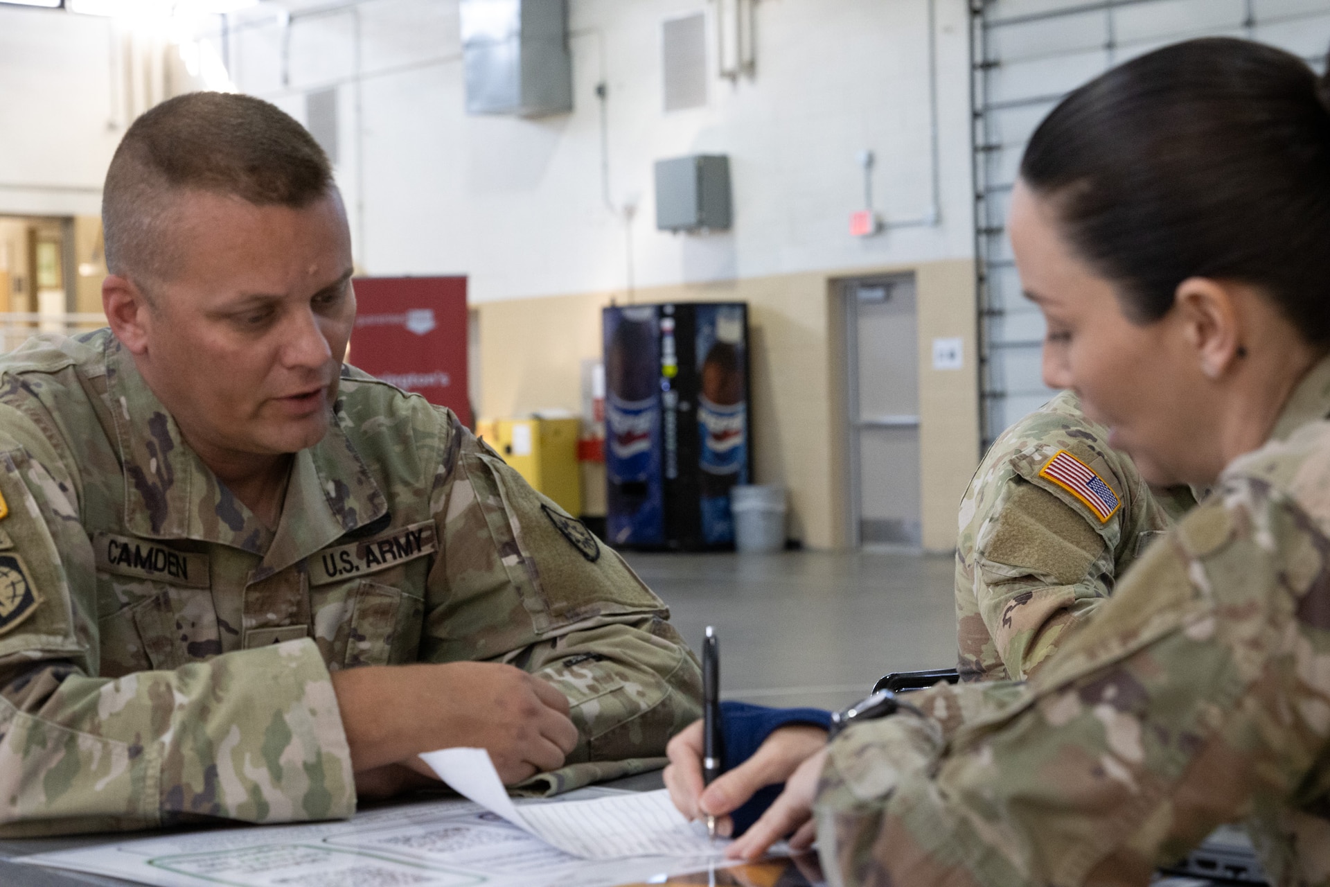 Staff Sgt. Whitney Click helping Master Sgt. Christopher Camden at Final Formation held in the Wellman armory located at the KYNG Boone center, April 20th, 2024 (U.S. Army Nation Guard photo by Staff Sgt. Lauren Kirk)