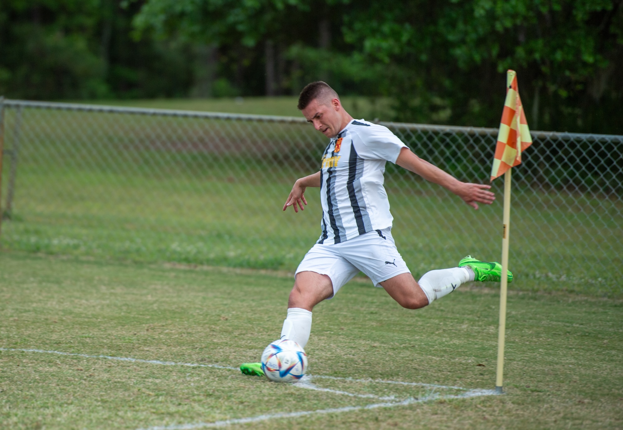 A soccer player kicks a ball during a game