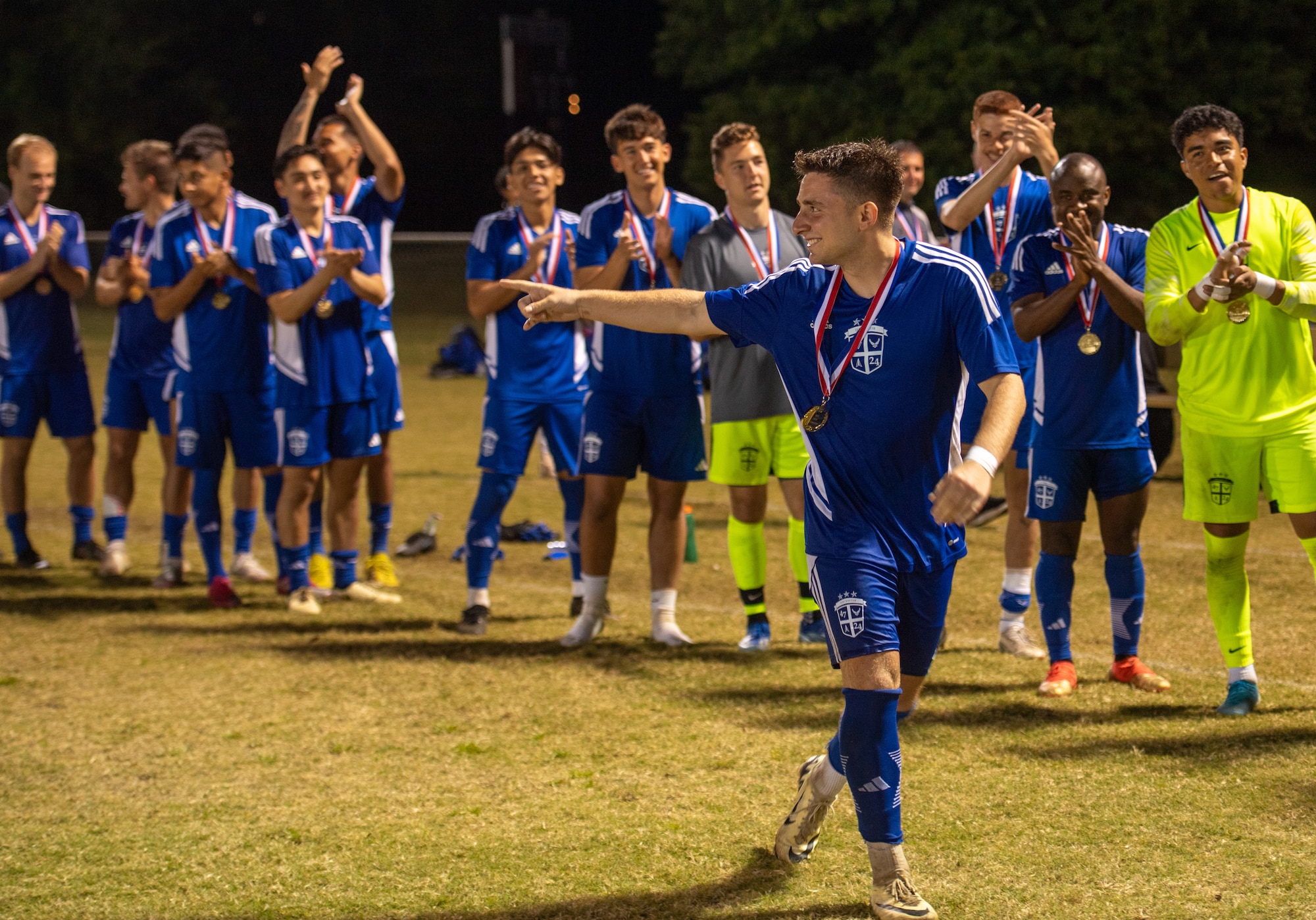 Air force soccer play in blue runs after receiving an award