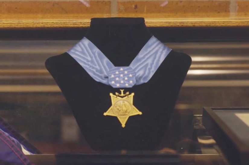 A medal hangs from a bust.