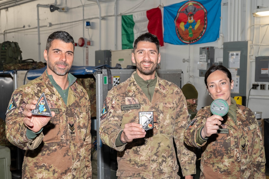 Italian Air Force service members pose for a photo with their custom patches.