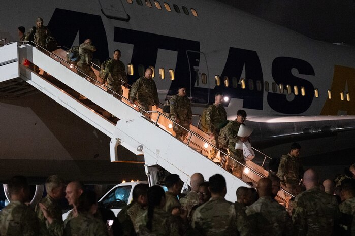 A photo of people deplaning a large jet.