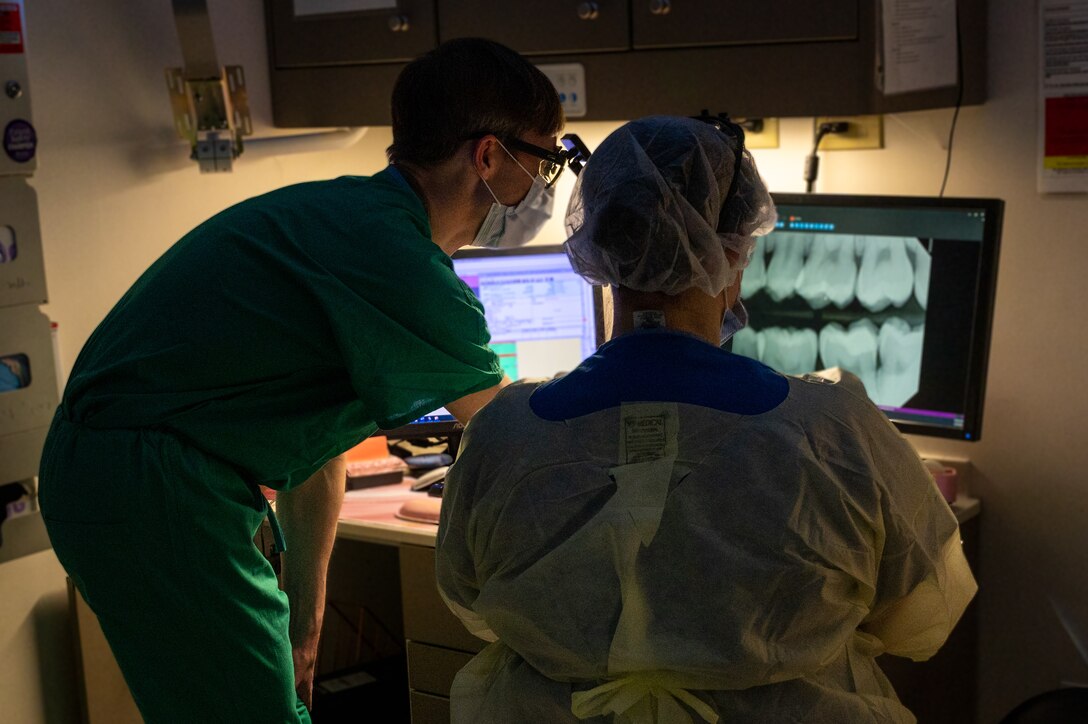 U.S. Air Force Lt. Col. Matthew Pastewait, 633d Dental Squadron orthodontist and Staff Sgt. Emily Crabtree, 633d Dental Squadron oral preventative assistant, review a patient’s x-ray at the dental clinic at Joint Base Langley-Eustis, Virginia, April 4, 2024. X-rays allow the dentist to see area between teeth and beneath fillings, to prevent cavities and other oral diseases. (U.S. Air Force photo by Airman 1st Class Skylar Ellis)