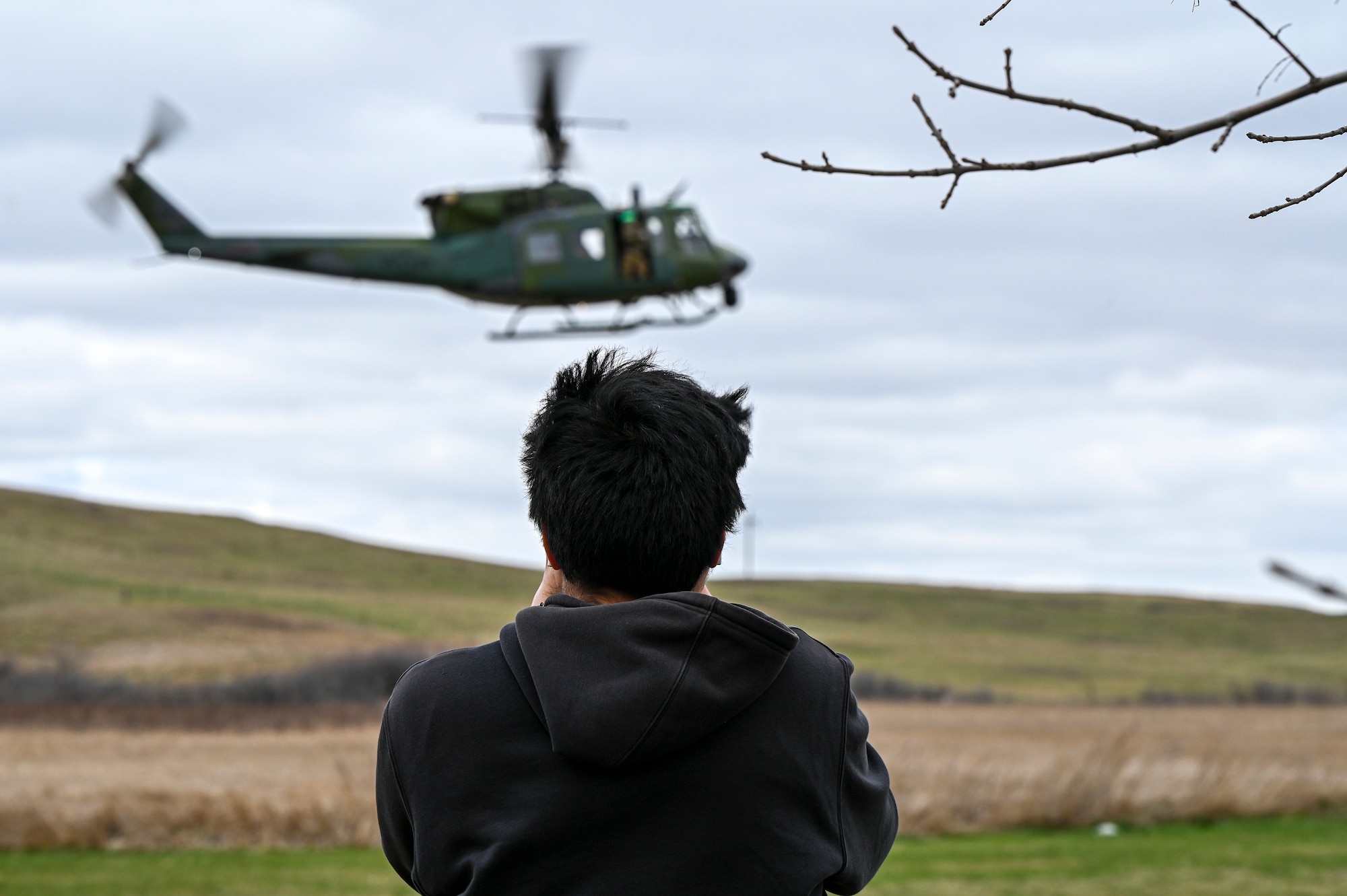 A student takes a photo of a helicopter landing.