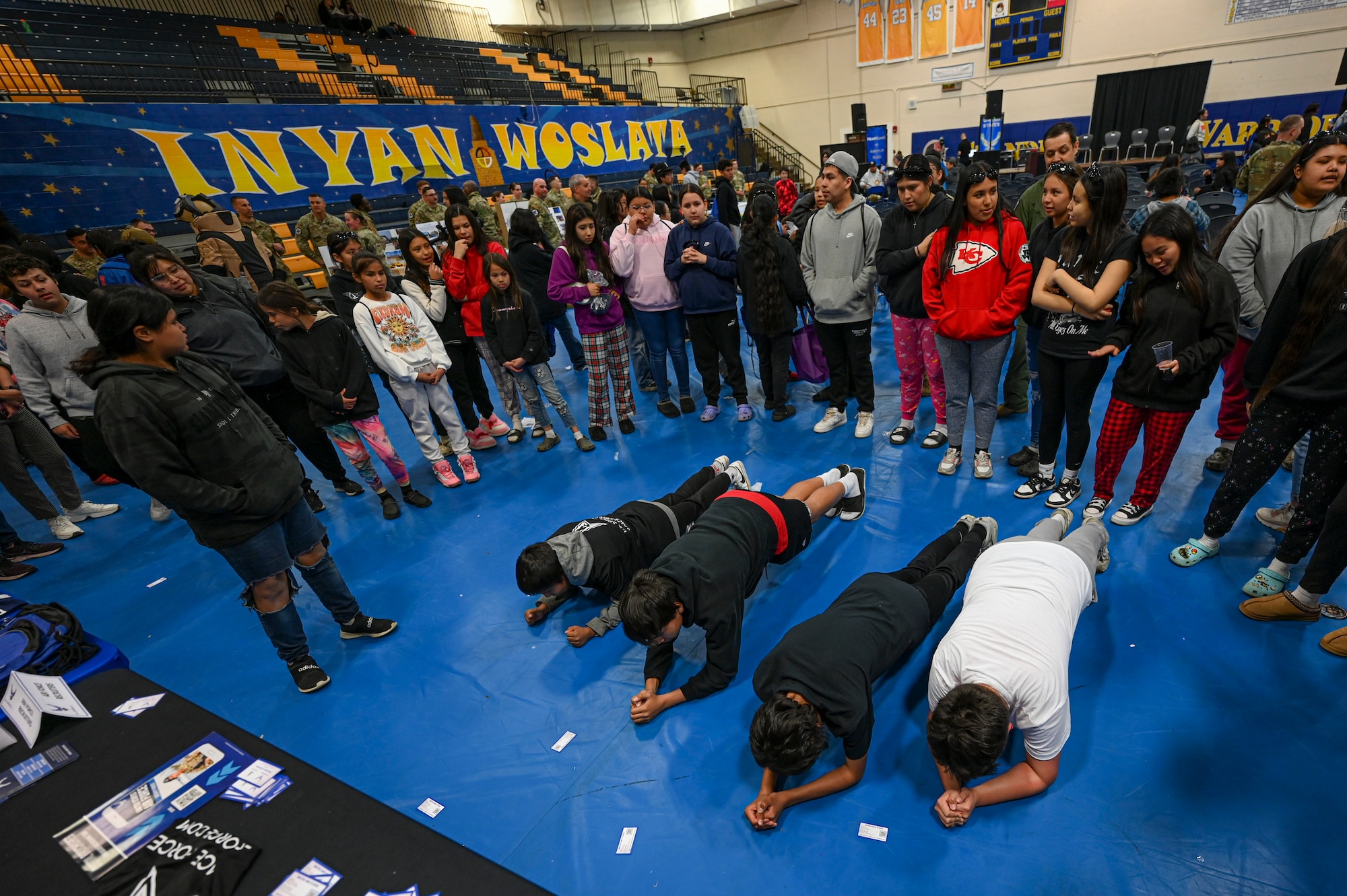 Students gather around other students doing exercises for a contest.