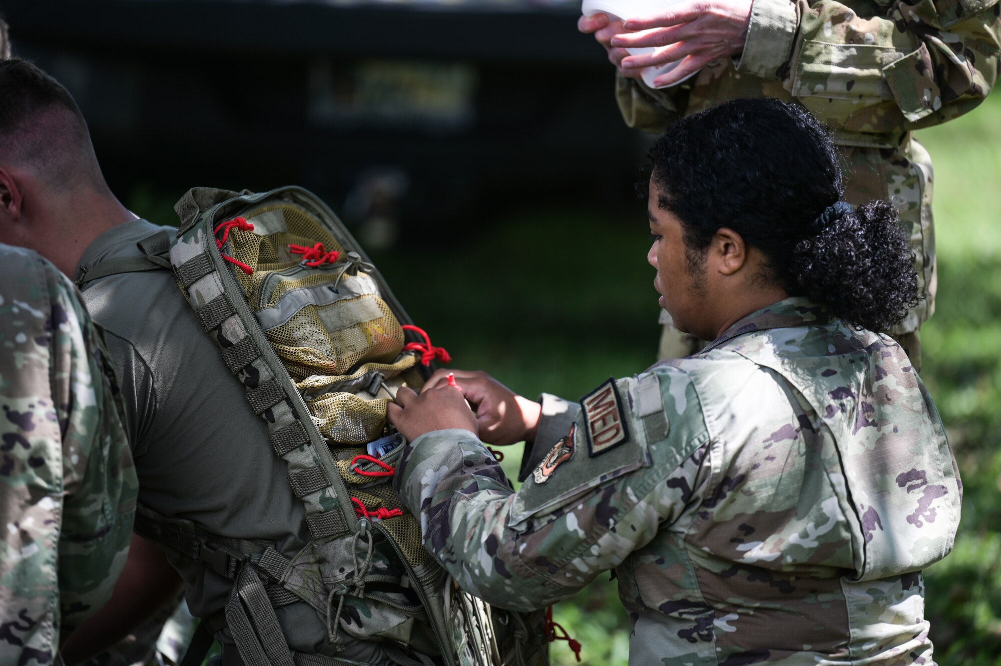 Airmen assigned to the 15th Medical Group utilize a first aid kit during a Tactical Combat Casualty Care and Ability to Survive and Operate relay at Joint Base Pearl Harbor-Hickam, Hawaii, April 17, 2024.  Eight teams participated in the relay, racing to see which team could accomplish each TCCC station correctly in a short time. (U.S. Air Force photo by Staff Sgt. Alan Ricker)