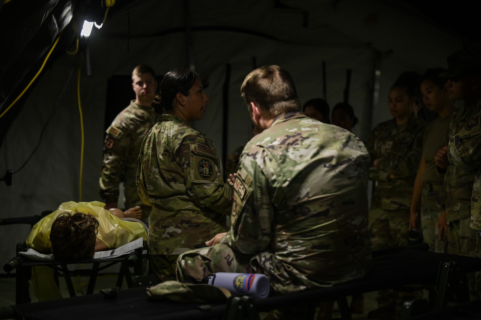 Airmen demonstrate medical skills in a tent.