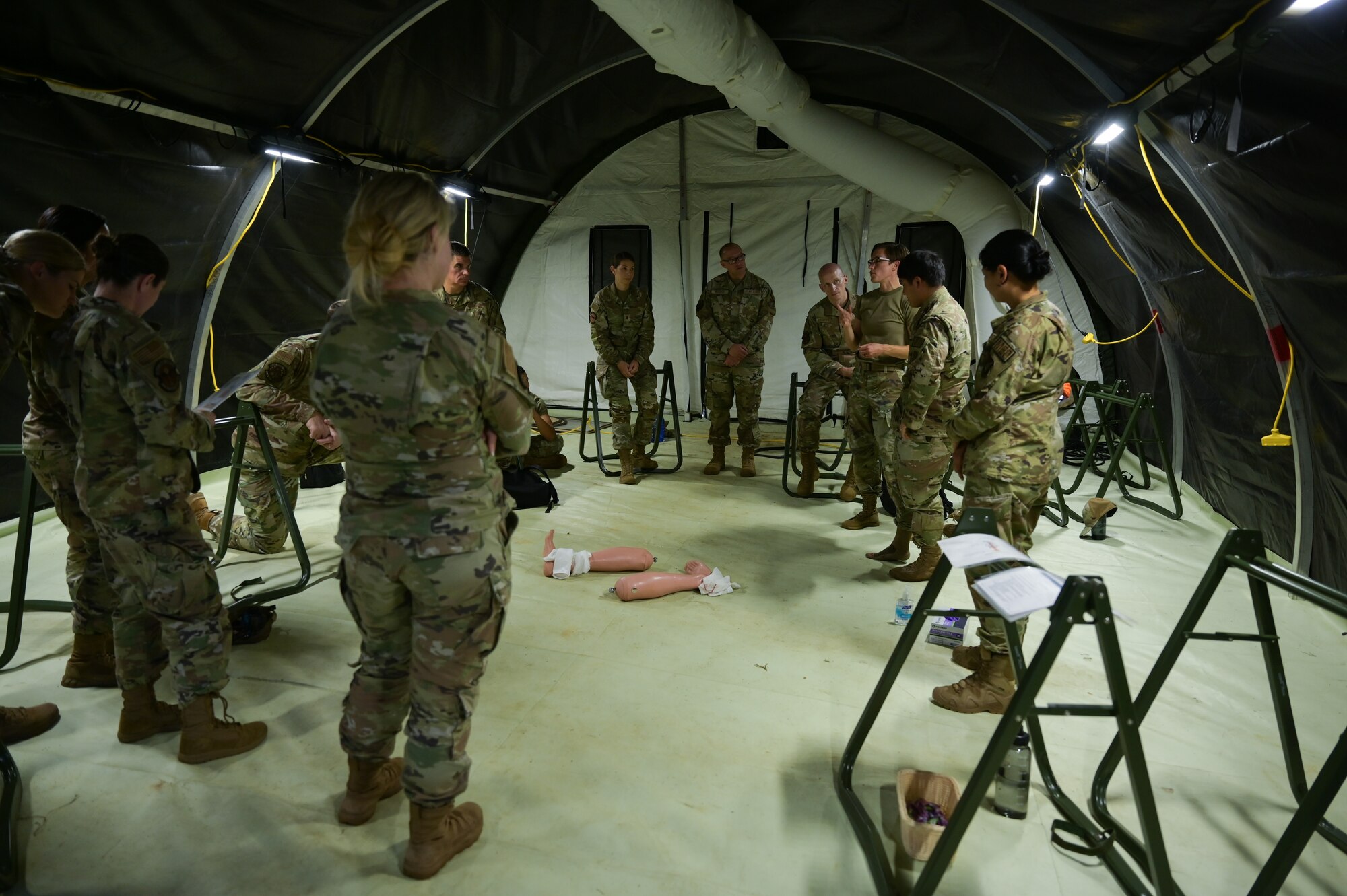Airmen demonstrate medical skills in a tent.