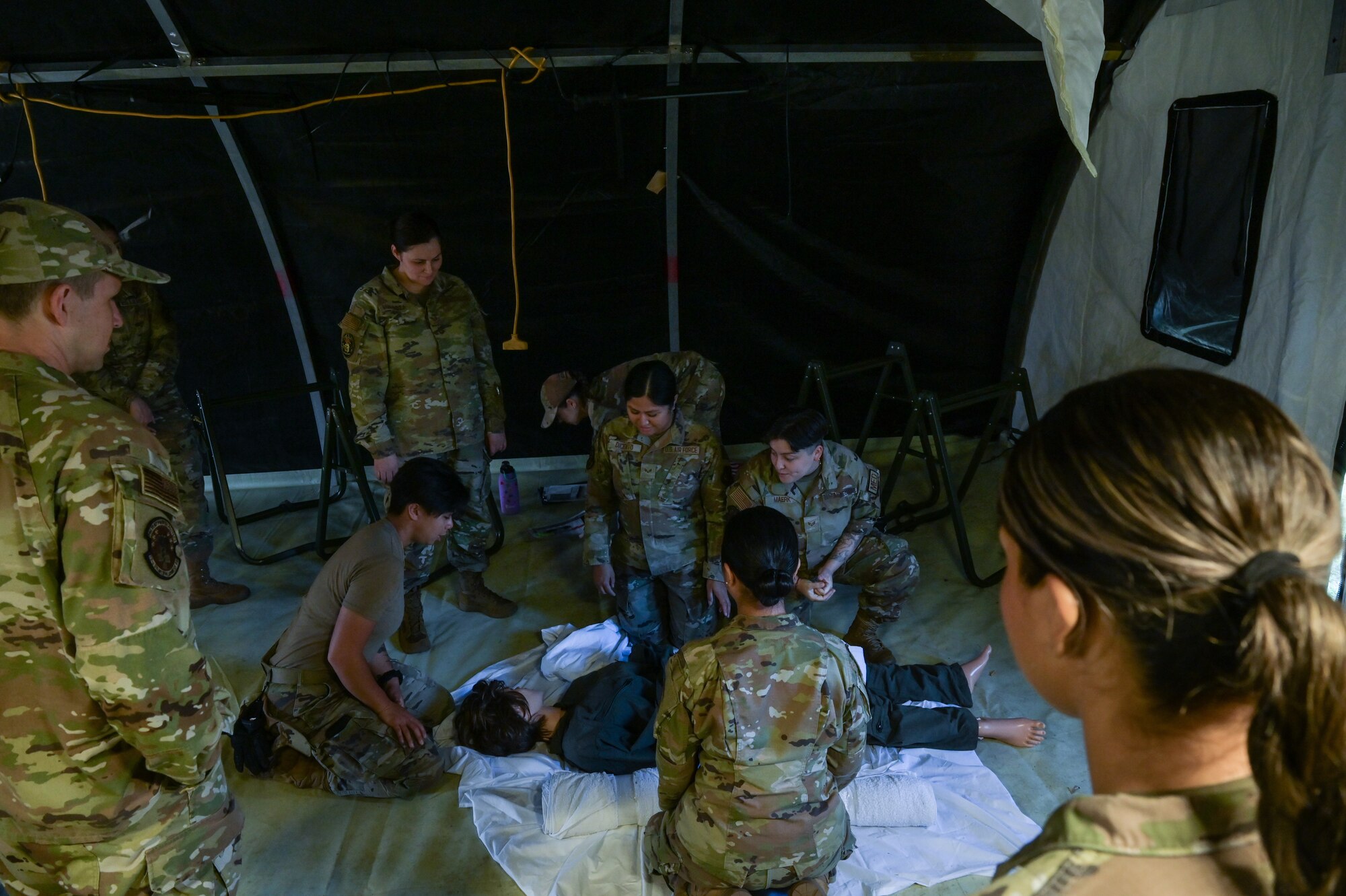 Airmen demonstrate medical skills in tent.